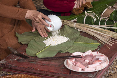 Midsection of woman holding food on table