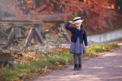 A funny little girl stands smiling in vintage clothing