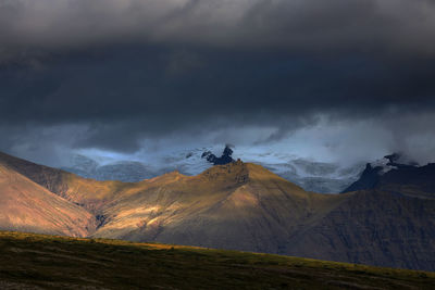 Scenic view of mountains against cloudy sky