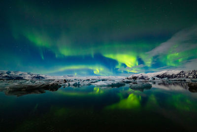 Scenic view of lake against sky at night during winter