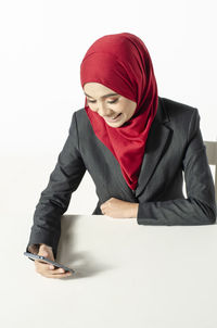 Portrait of smiling young woman against white background