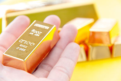 Close-up of hand holding gold bar