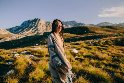 Man standing on field against mountain range