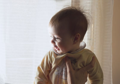 Portrait of cute boy looking away at home