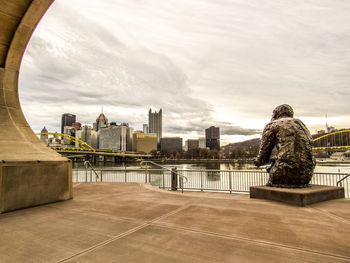 Rear view of people looking at city buildings against sky