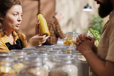 Midsection of woman holding drink on table