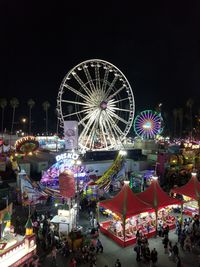 Illuminated ferris wheel against clear sky at night