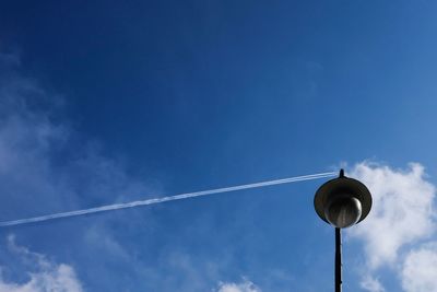 Low angle view of vapor trail against blue sky