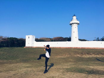Full length of woman standing against clear blue sky