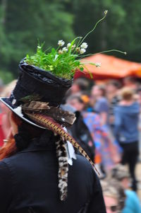 Close-up of man wearing decorated hat with plants