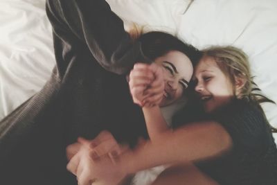 Directly above shot of mother and daughter playing on bed at home