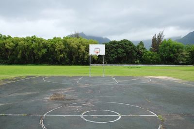 Empty basketball court against cloudy sky