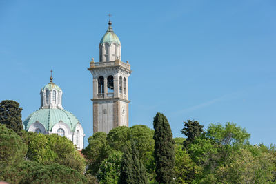 Low angle view of trees and building against sky