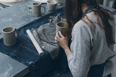 Woman making clay cup