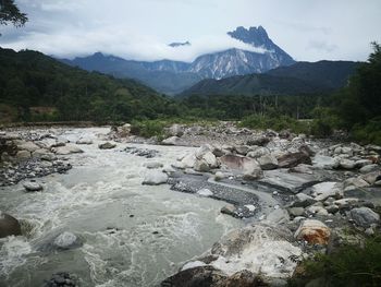 Scenic view of river and mountains against sky