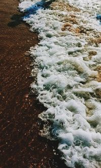 High angle view of waves rushing towards shore