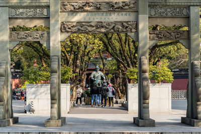 People walking in park by building