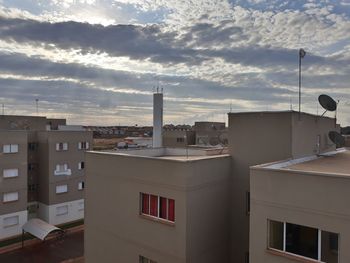 Cityscape against cloudy sky