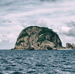 Scenic view of rock formation in sea against sky