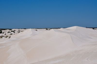 Sand dunes in desert against clear sky