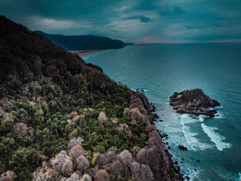 Scenic view of sea against sky and viewed drilling rig.