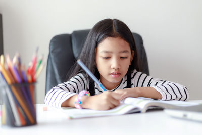 Portrait of girl sitting on table