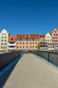 Buildings in city against clear blue sky