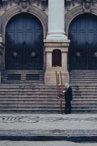 Rear view of man walking on steps