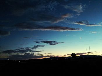 Scenic view of silhouette field against dramatic sky