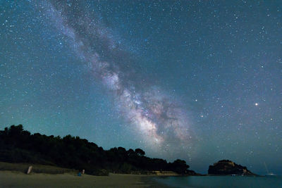 Scenic view of beach against star field at dusk