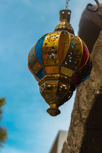 Low angle view of ornate hanging against sky