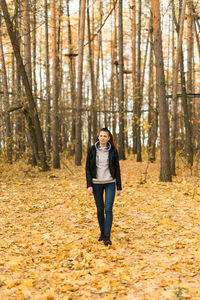 Full length of woman standing in forest