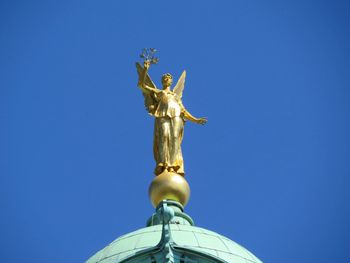 Low angle view of statue against clear blue sky