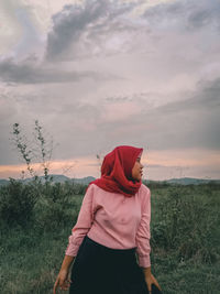 Man standing on field against sky during sunset