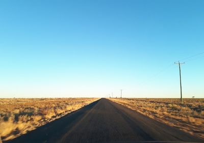 Road passing through landscape against clear sky