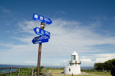 Rokkousaki lighthouse and information sign by sea against sky