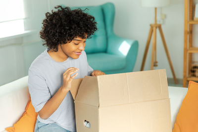 Young woman using laptop while sitting on sofa at home