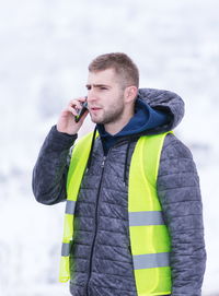 Young man using smart phone during winter