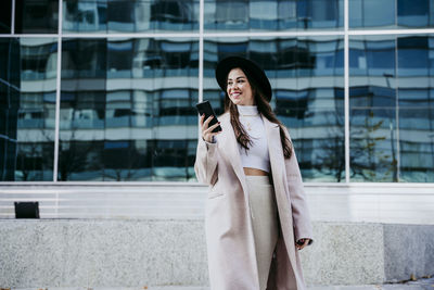 Woman standing against wall in city