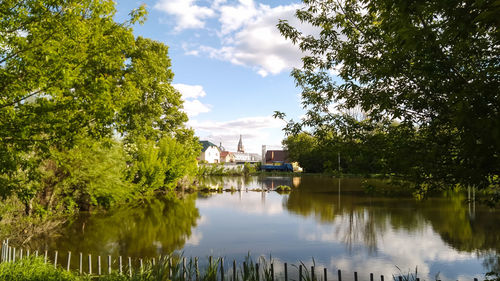 Scenic view of lake by trees against sky