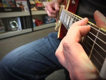 Close-up of man playing guitar