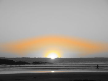 Scenic view of beach against clear sky during sunset