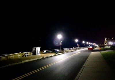 Road passing through illuminated tunnel