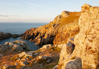 Rock formations by sea against sky