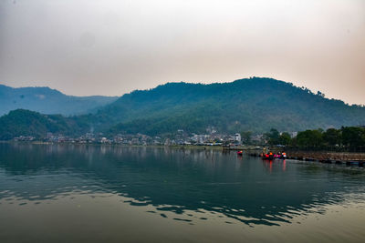 Scenic view of lake by mountains against sky