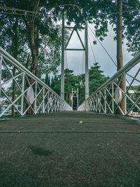 Bridge in forest against sky