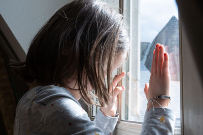 Girl looking through window