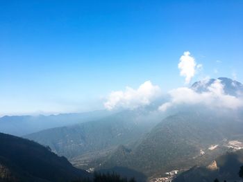 Scenic view of mountains against blue sky