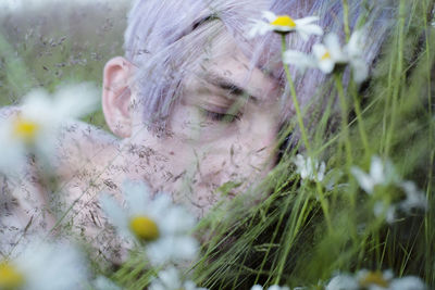 Close-up of teenage boy sleeping by flowers