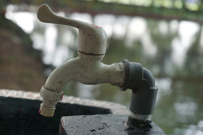 Close-up of water faucet against blurred background